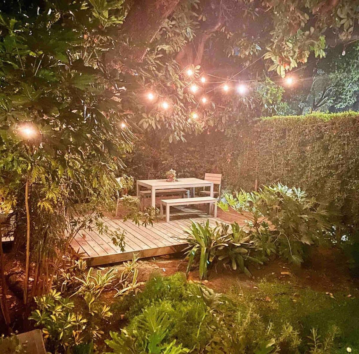 Deck under string lights in the De Longpre garden at night